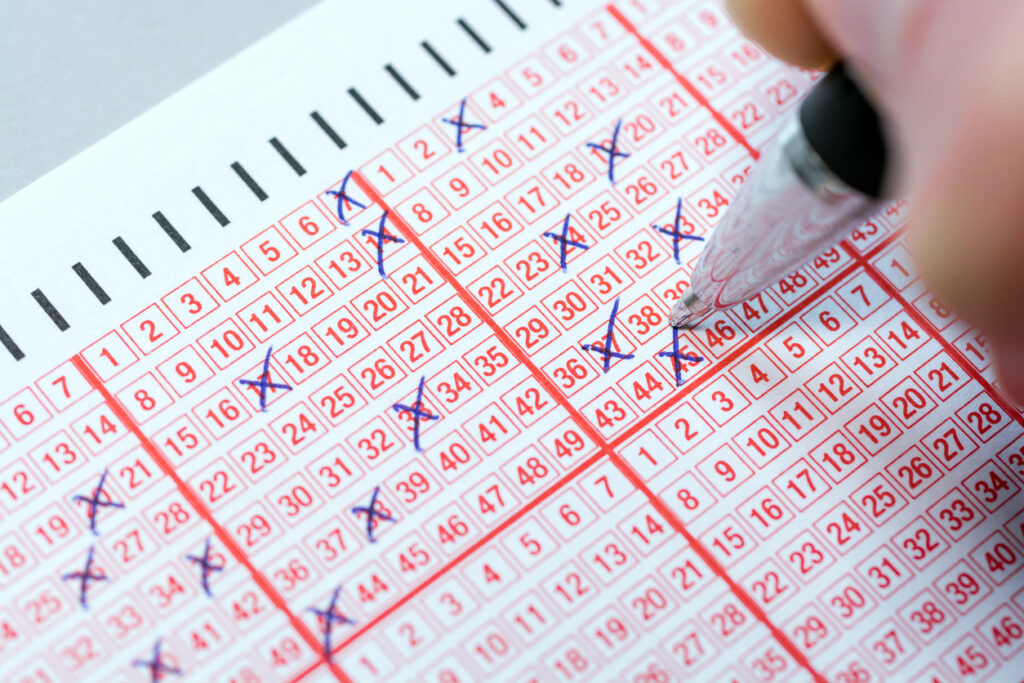 Completing a lottery ticket with a pen and hoping for quick riches